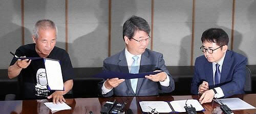 삼성전자가 '반도체 백혈병' 문제에 대해 사과했다. 지난 7월 24일 김선식 삼성전자 전무(맨 오른쪽), 김지형 조정위원회 위원장(가운데), 황상기 반올림 대표가 중재합의서에 서명하고 있다. <연합뉴스 제공>